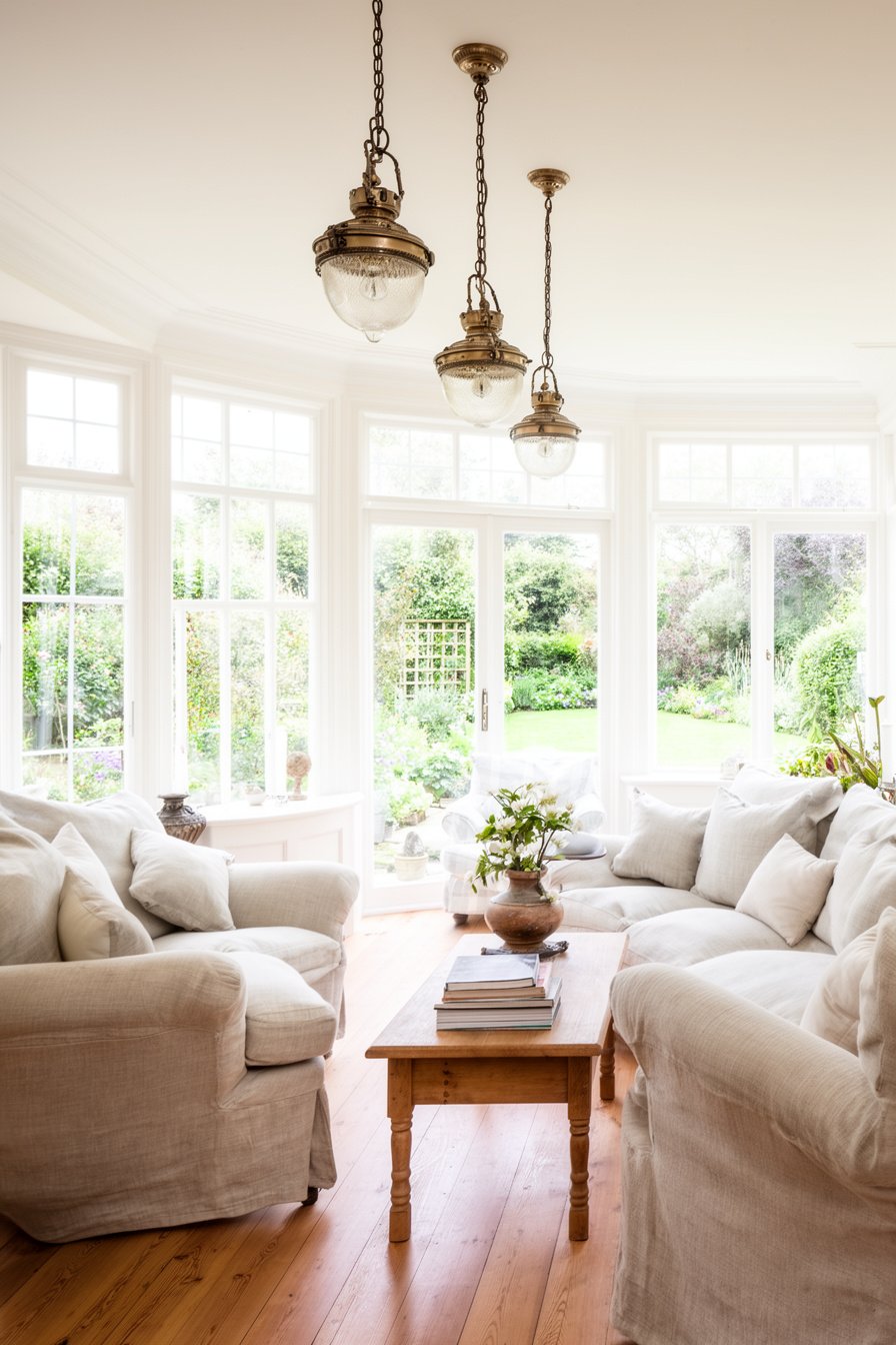 Wohnzimmer im Landhausstil mit Gartenblick und Vintage-Leuchten